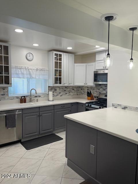 kitchen featuring stainless steel appliances, white cabinetry, decorative light fixtures, gray cabinets, and decorative backsplash