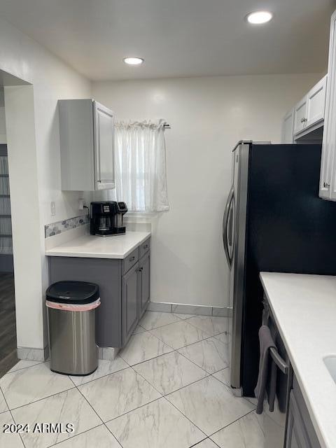 kitchen featuring gray cabinets, stainless steel refrigerator, white cabinetry, and dishwashing machine