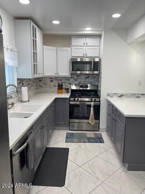 kitchen with white cabinetry, appliances with stainless steel finishes, sink, and gray cabinetry