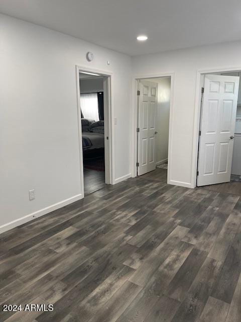 unfurnished room with dark hardwood / wood-style flooring