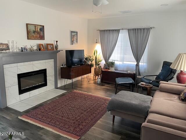 living room featuring a fireplace, wood-type flooring, and ceiling fan