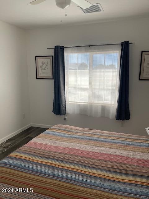 unfurnished bedroom featuring dark wood-type flooring and ceiling fan