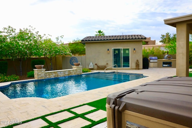 view of swimming pool featuring an outdoor structure, a patio area, and a grill