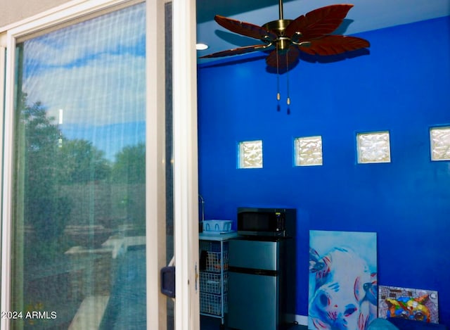 bedroom with stainless steel fridge and ceiling fan