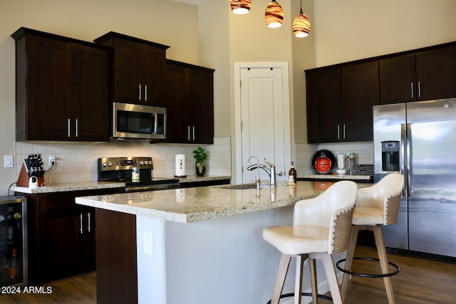 kitchen featuring stainless steel appliances, dark wood-type flooring, tasteful backsplash, and pendant lighting