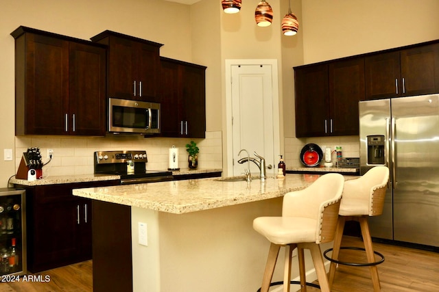 kitchen featuring stainless steel appliances, sink, light hardwood / wood-style floors, and tasteful backsplash