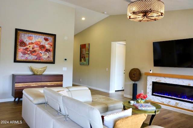 living room with hardwood / wood-style floors, a high end fireplace, and lofted ceiling