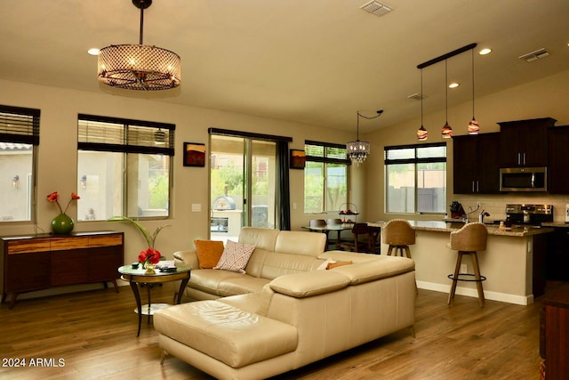 living room featuring a wealth of natural light, lofted ceiling, and hardwood / wood-style flooring