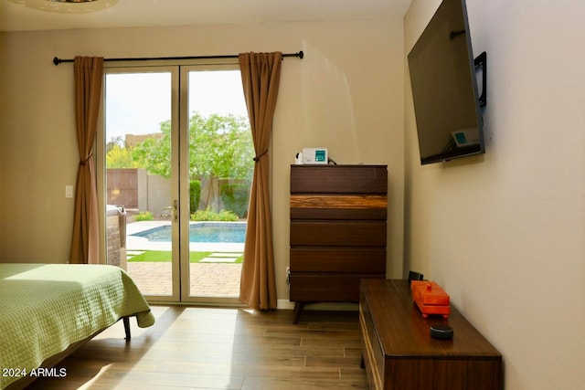 bedroom featuring wood-type flooring, access to outside, and multiple windows