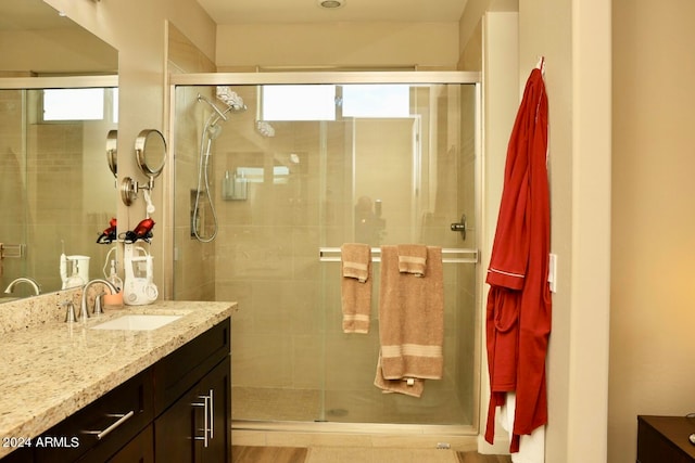 bathroom featuring walk in shower and vanity