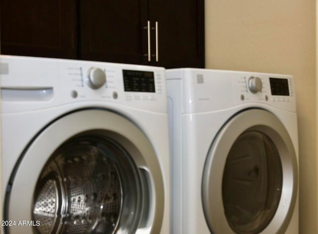 laundry area with washer and clothes dryer and cabinets