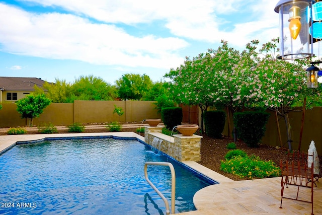 view of swimming pool with a patio and pool water feature