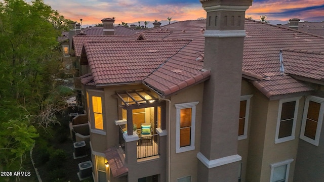 14250 W Wigwam Blvd Unit 2722, Litchfield Park, AZ 85340 - property exterior at dusk with a tiled roof, a chimney, and stucco siding