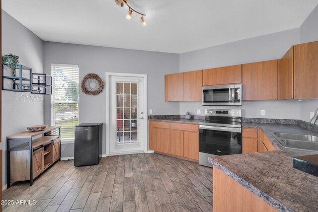 14250 W Wigwam Blvd Unit 2722, Litchfield Park, AZ 85340 - kitchen featuring appliances with stainless steel finishes, a sink, light wood finished floors, and dark countertops