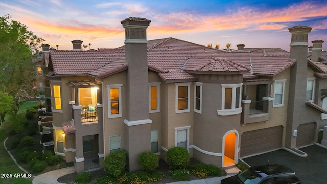 14250 W Wigwam Blvd Unit 2722, Litchfield Park, AZ 85340 - view of front facade featuring a tiled roof, a chimney, stucco siding, and an attached garage