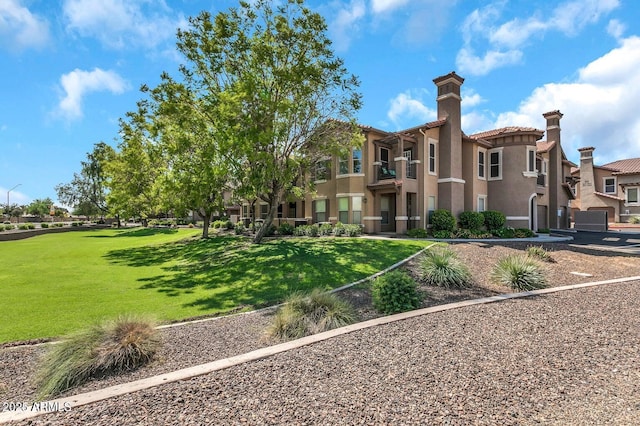14250 W Wigwam Blvd Unit 2722, Litchfield Park, AZ 85340 - back of house featuring stucco siding, a chimney, a yard, and a tile roof
