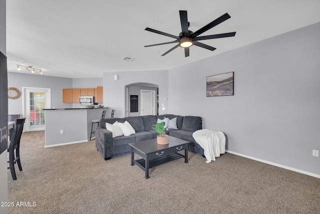 14250 W Wigwam Blvd Unit 2722, Litchfield Park, AZ 85340 - living room with arched walkways, light carpet, a ceiling fan, and baseboards