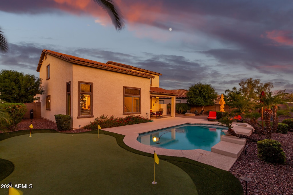 pool at dusk featuring a patio