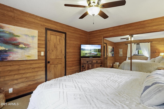 bedroom with carpet, wooden walls, and ceiling fan