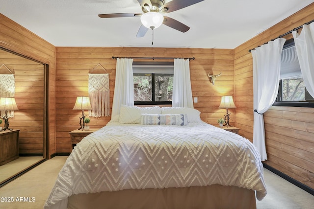 bedroom with wooden walls, light colored carpet, and ceiling fan