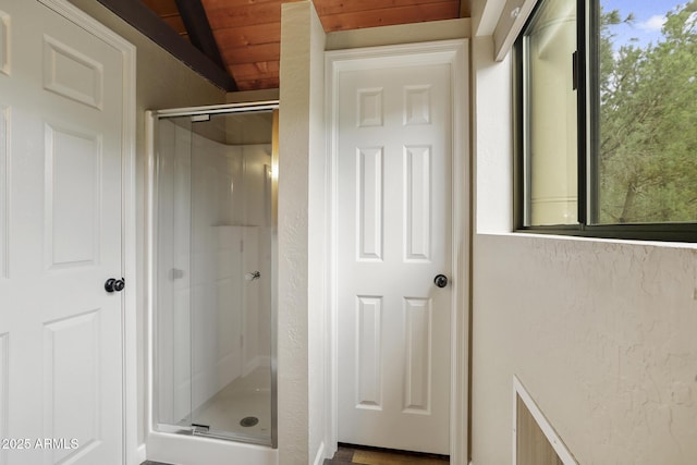 bathroom with a shower with door and wooden ceiling