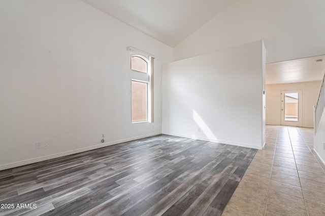 unfurnished room featuring dark wood-type flooring and high vaulted ceiling