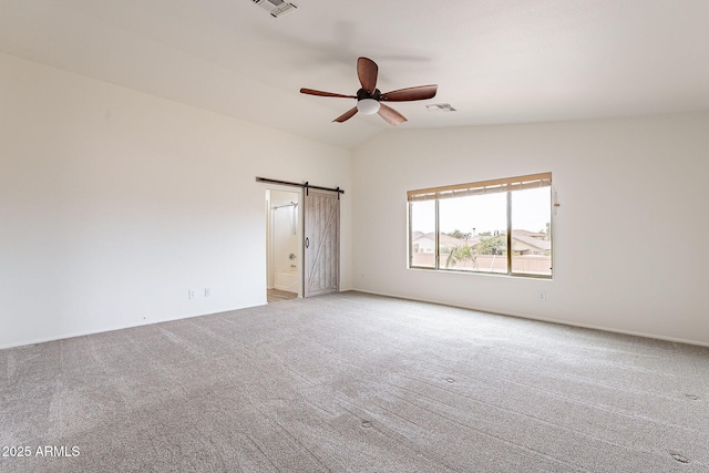 unfurnished room with light carpet, vaulted ceiling, ceiling fan, and a barn door