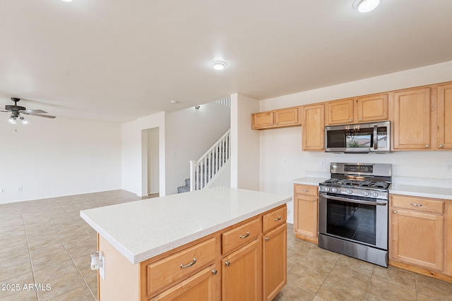 kitchen featuring a center island, light tile patterned floors, stainless steel appliances, and ceiling fan