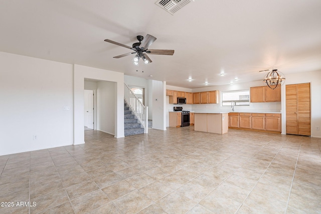 unfurnished living room featuring ceiling fan with notable chandelier, light tile patterned floors, and sink