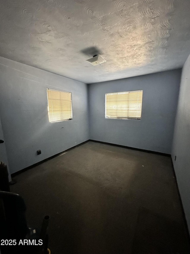 spare room featuring plenty of natural light and a textured ceiling