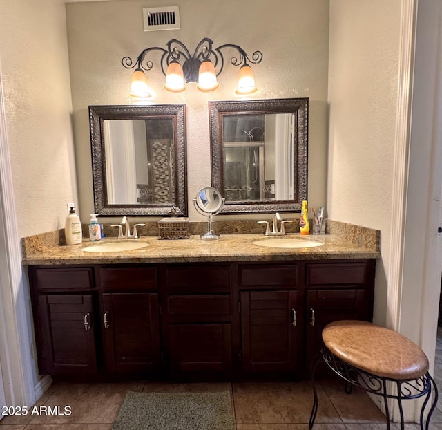 8908 W Sheridan St, Phoenix, AZ 85037 - bathroom with a textured wall, double vanity, tile patterned floors, and a shower