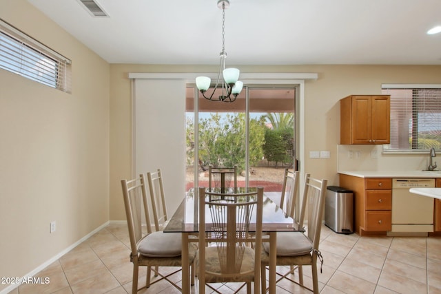 dining room featuring an inviting chandelier, sink, and light tile patterned floors