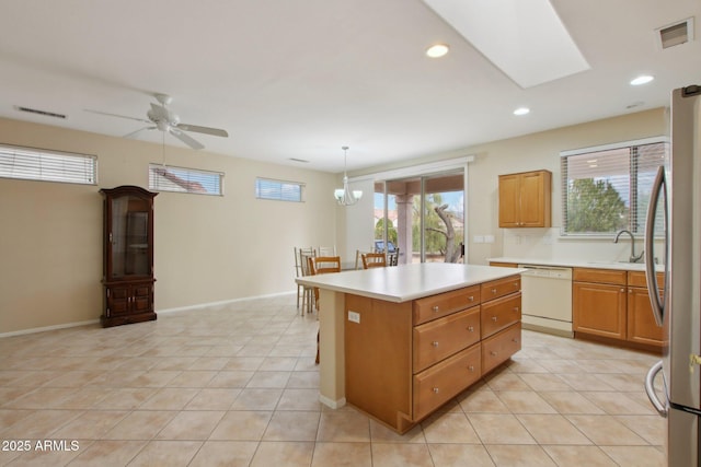 kitchen featuring light tile patterned flooring, decorative light fixtures, dishwasher, and a kitchen island