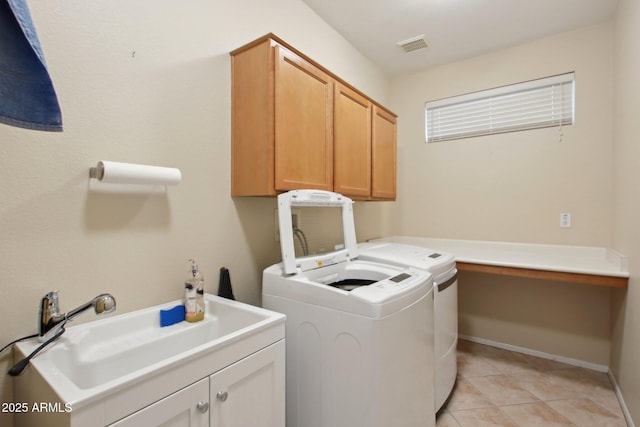 washroom with independent washer and dryer, cabinets, sink, and light tile patterned floors