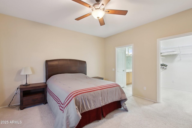 carpeted bedroom featuring ceiling fan, a walk in closet, connected bathroom, and a closet