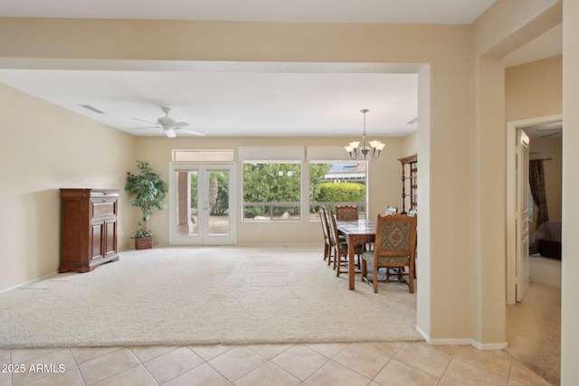 carpeted dining space with ceiling fan with notable chandelier