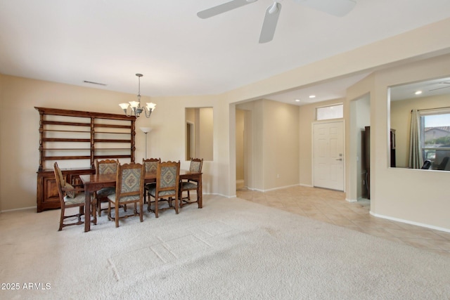 dining room with light carpet and ceiling fan with notable chandelier