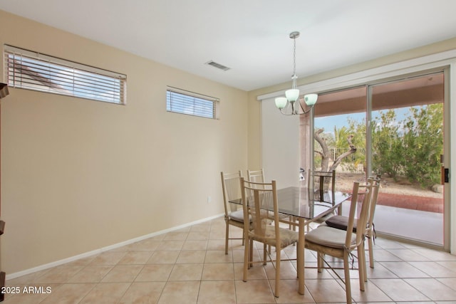 dining area with light tile patterned flooring and an inviting chandelier