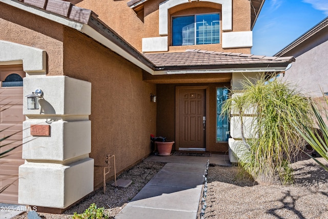 property entrance featuring a tiled roof and stucco siding