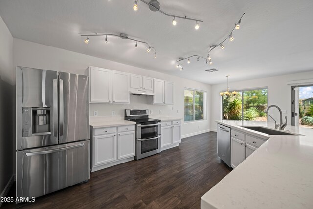 2168 E Vista Bonita Dr, Phoenix, AZ 85024 - kitchen with stainless steel appliances, a sink, under cabinet range hood, dark wood-style flooring, and white cabinets