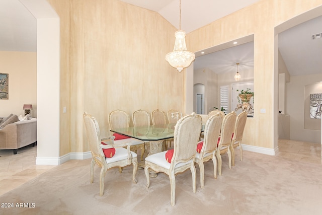 dining space featuring a notable chandelier, light colored carpet, and lofted ceiling