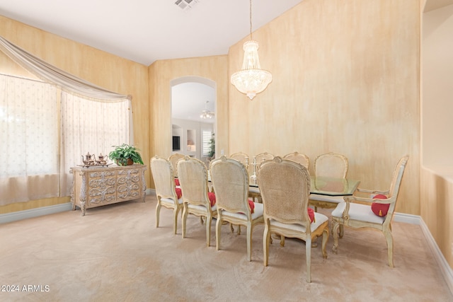 dining area with carpet flooring and a notable chandelier