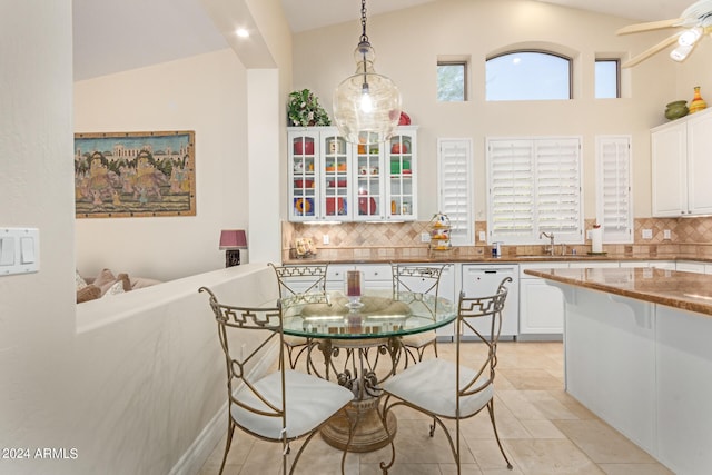 dining space with high vaulted ceiling, ceiling fan, and sink