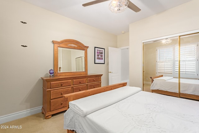 bedroom featuring ceiling fan, a closet, light carpet, and lofted ceiling