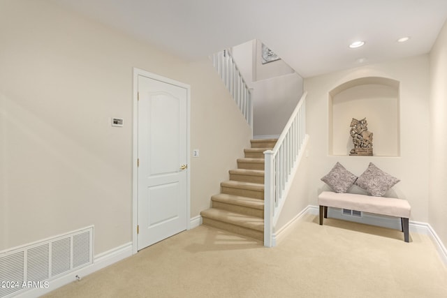 staircase featuring carpet flooring