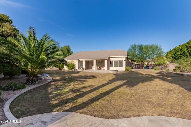 back of property featuring a lawn