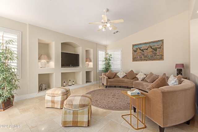 tiled living room featuring built in shelves, ceiling fan, and lofted ceiling