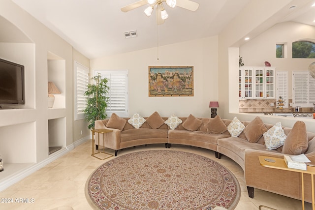 tiled living room featuring ceiling fan, lofted ceiling, and built in shelves