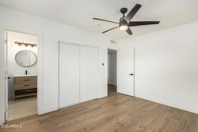 unfurnished bedroom with ceiling fan, light wood-type flooring, and a closet