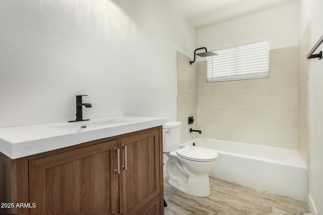 full bathroom with toilet, wood-type flooring, vanity, and tiled shower / bath combo